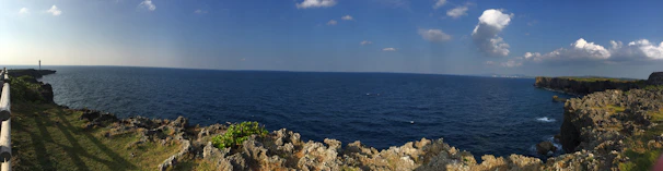 A panoramic view of a famous Brazilian lighthouse standing tall by the ocean on a sunny day.