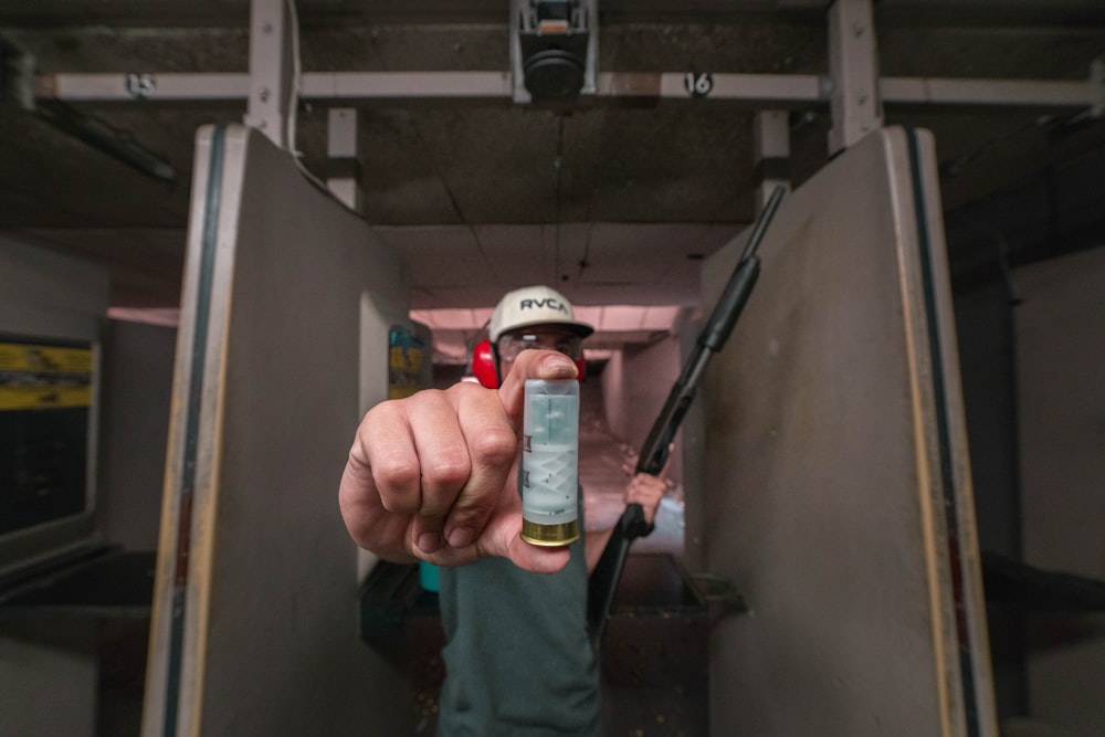 person holding shotgun bullet