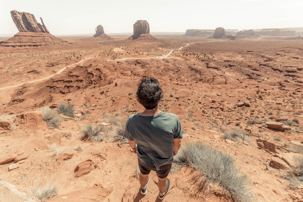 man standing while facing desert during daytime