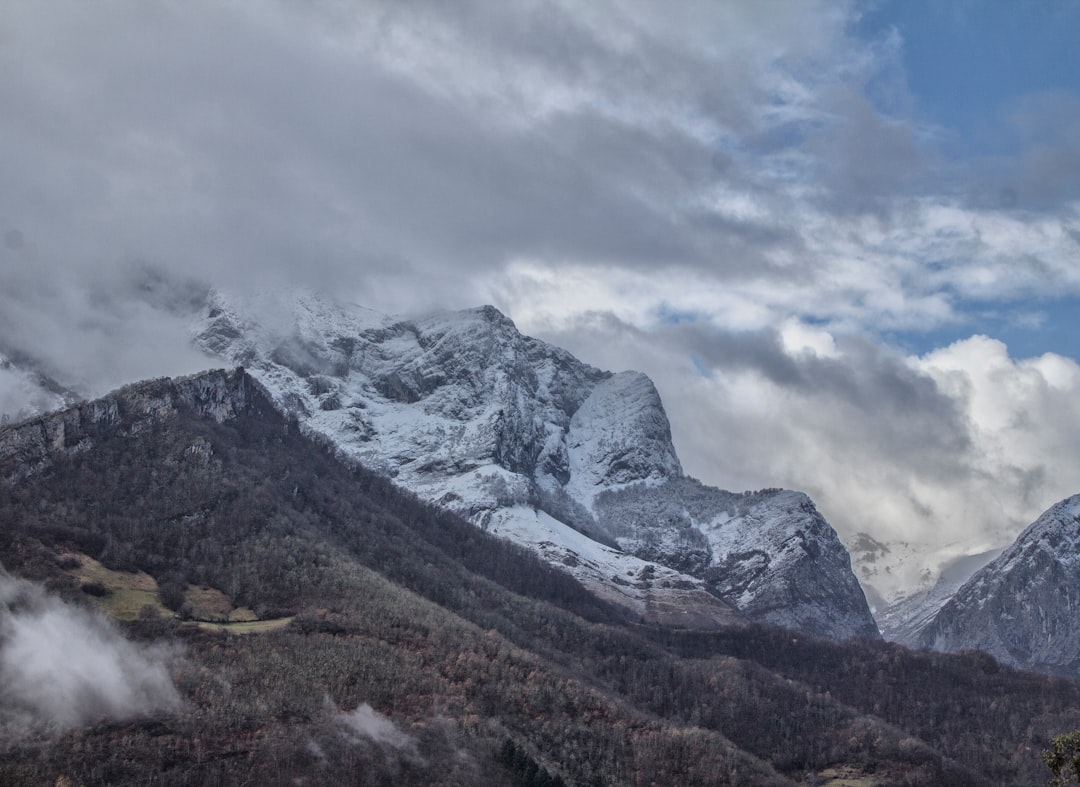 white clouds over snow capped mountain peak