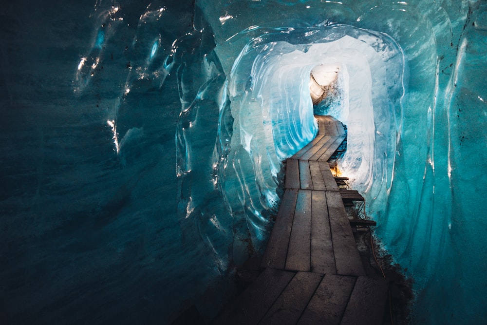 Eine Person geht durch einen Tunnel im Eis