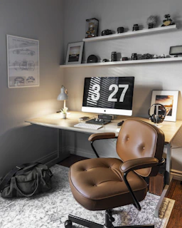 Bureau avec ordinateur Mac et fauteuil en cuir