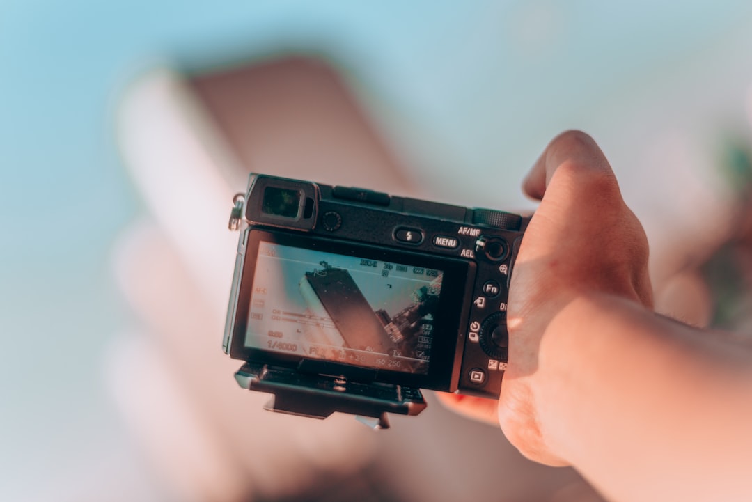 person pointing camera on high rise building,