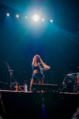 A performer engaging the crowd with energetic dance moves on stage.