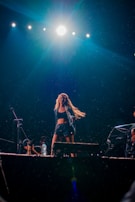 An artist mid-performance, sweat glistening, lost in the music under a spotlight.