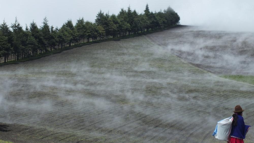 woman carrying white sack on farm field