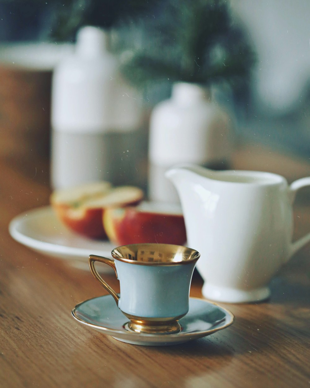 Fotografía de enfoque selectivo de taza de té junto a dos rodajas de manzana