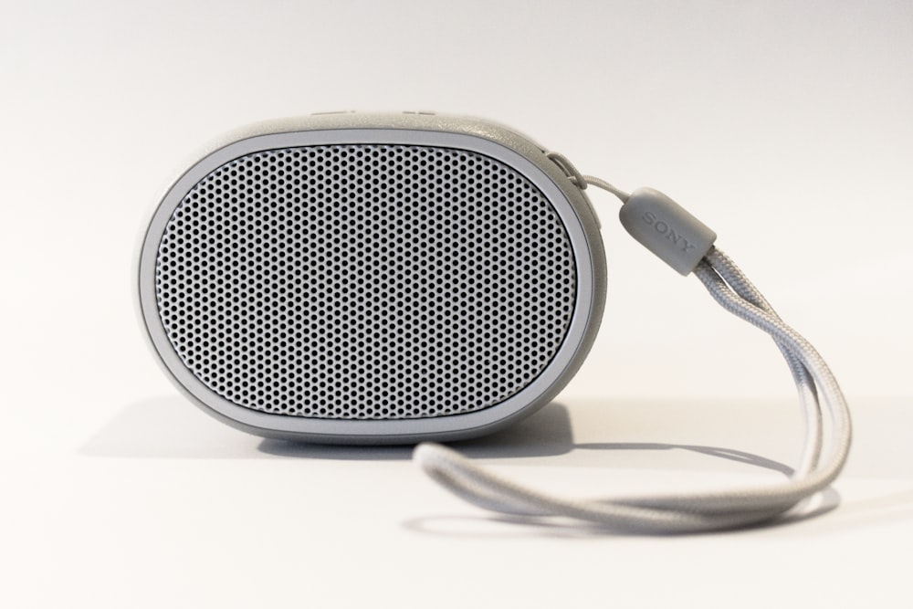 oval grey portable speaker on white surface