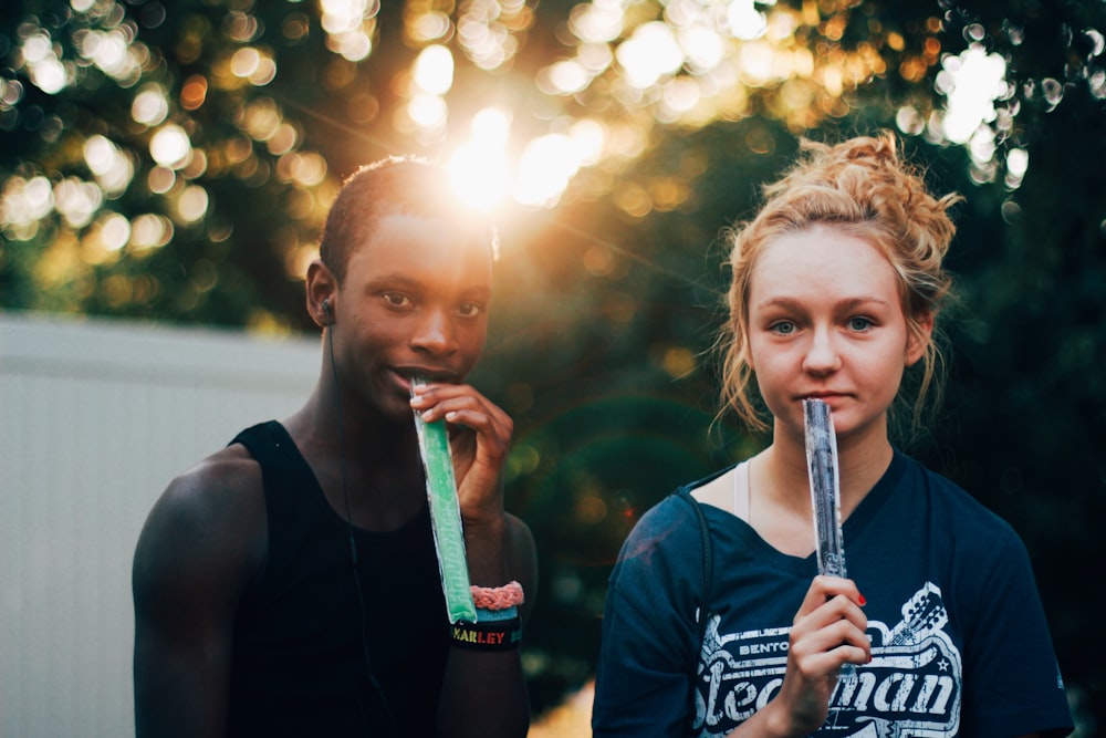 man and woman holding candy pops