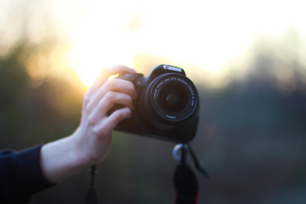 person using Canon DSLR camera