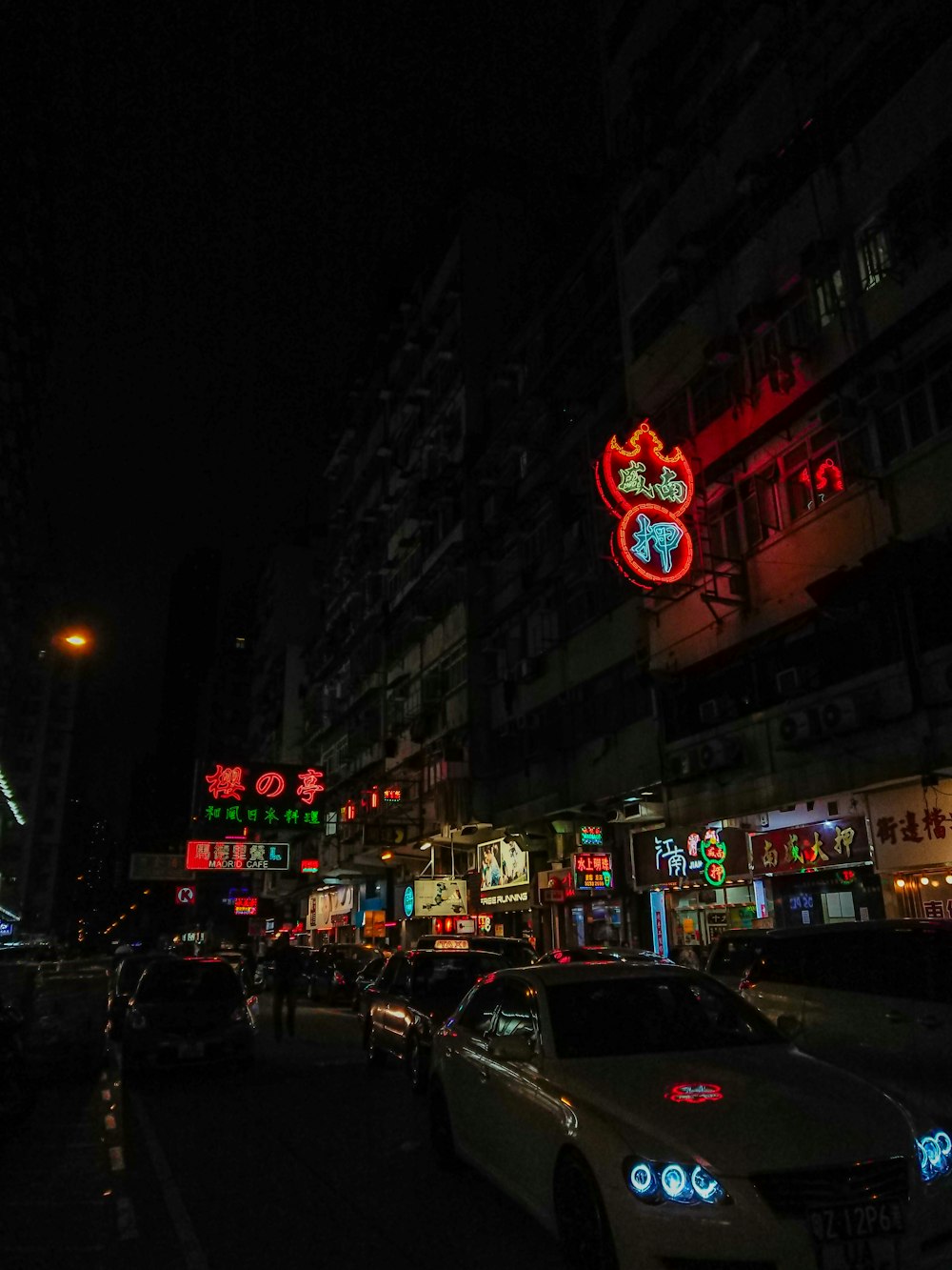 veicoli che passano accanto all'edificio con insegne al neon