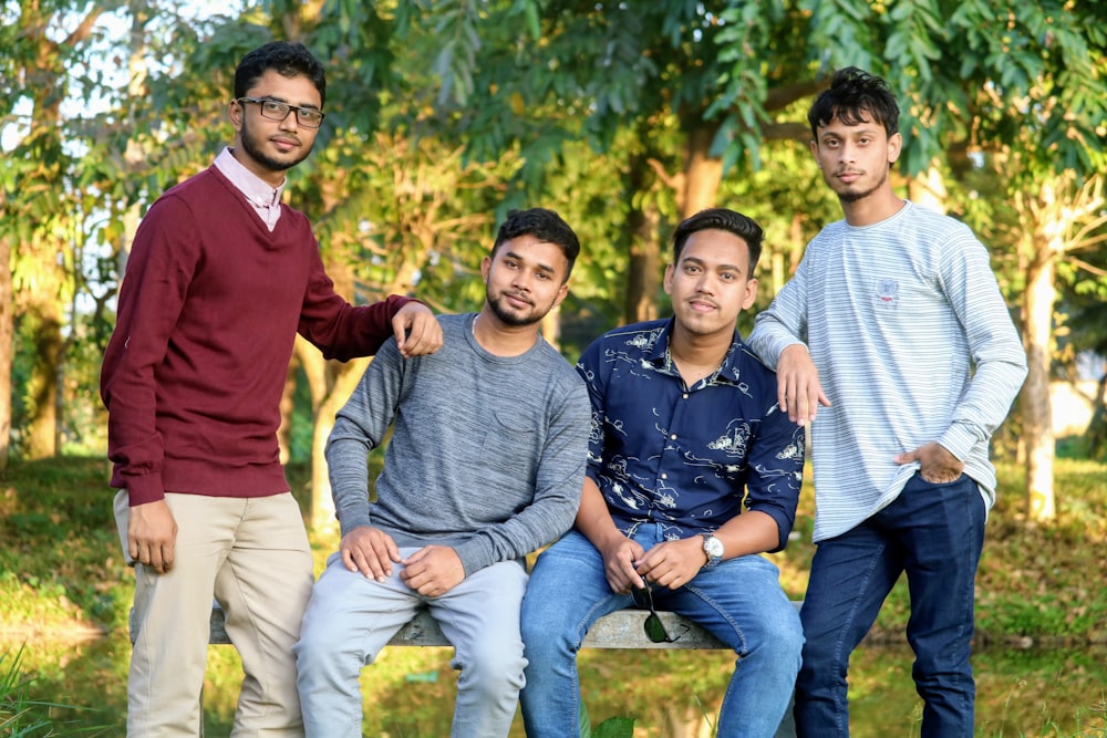 two men sitting on bench near two men standing