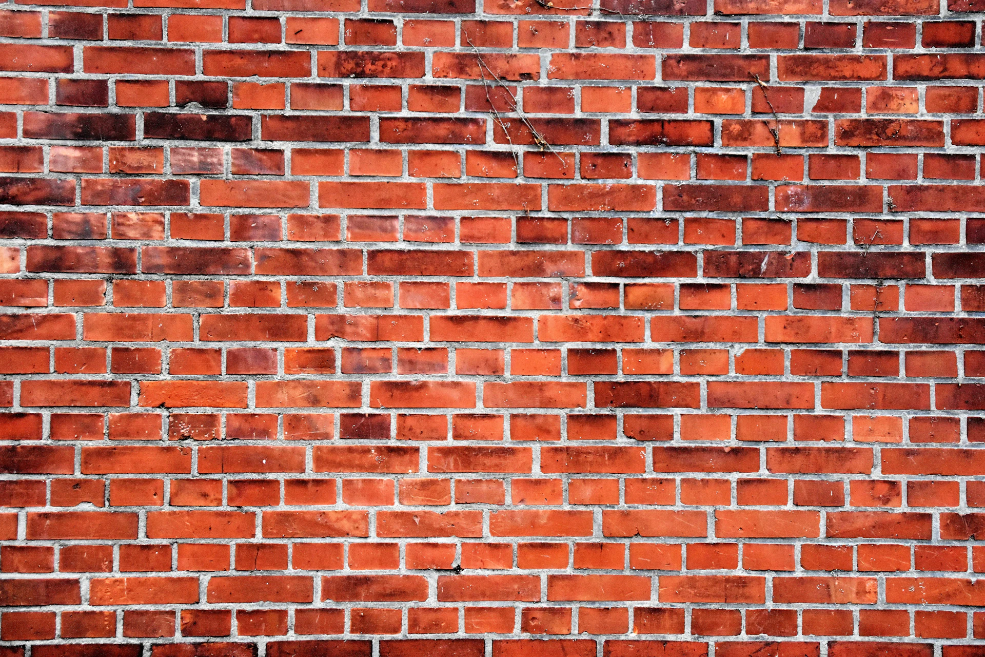 Weathered red brick wall with traditional mortar joints