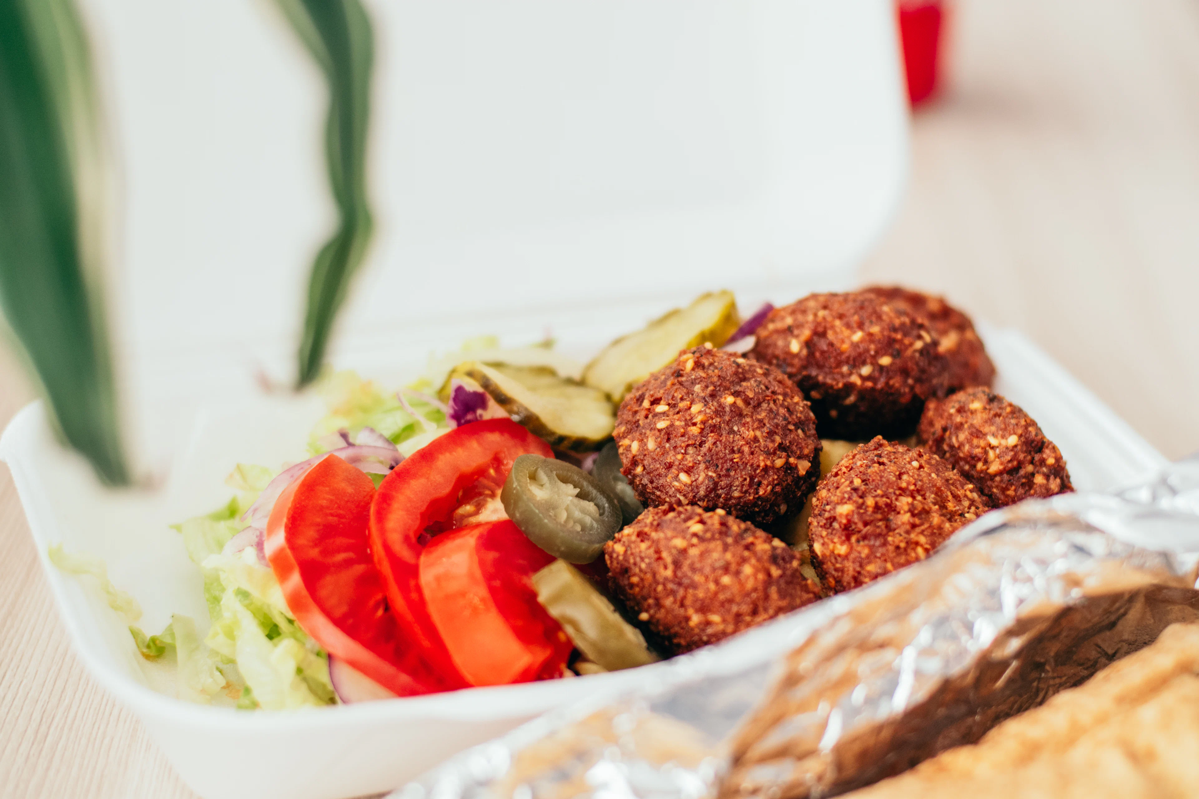 Falafel balls in a bowl with tomatoes and fresh greens