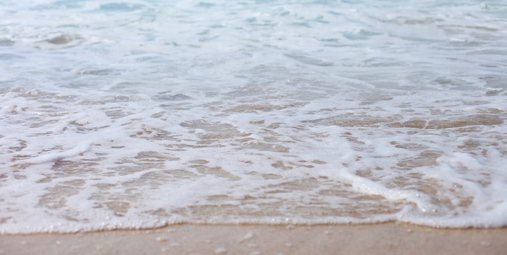 sea foam on shore during daytime