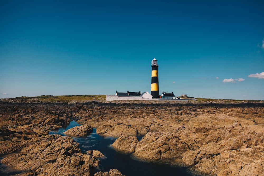 blue and yellow lighthouse under blue sky during daytime