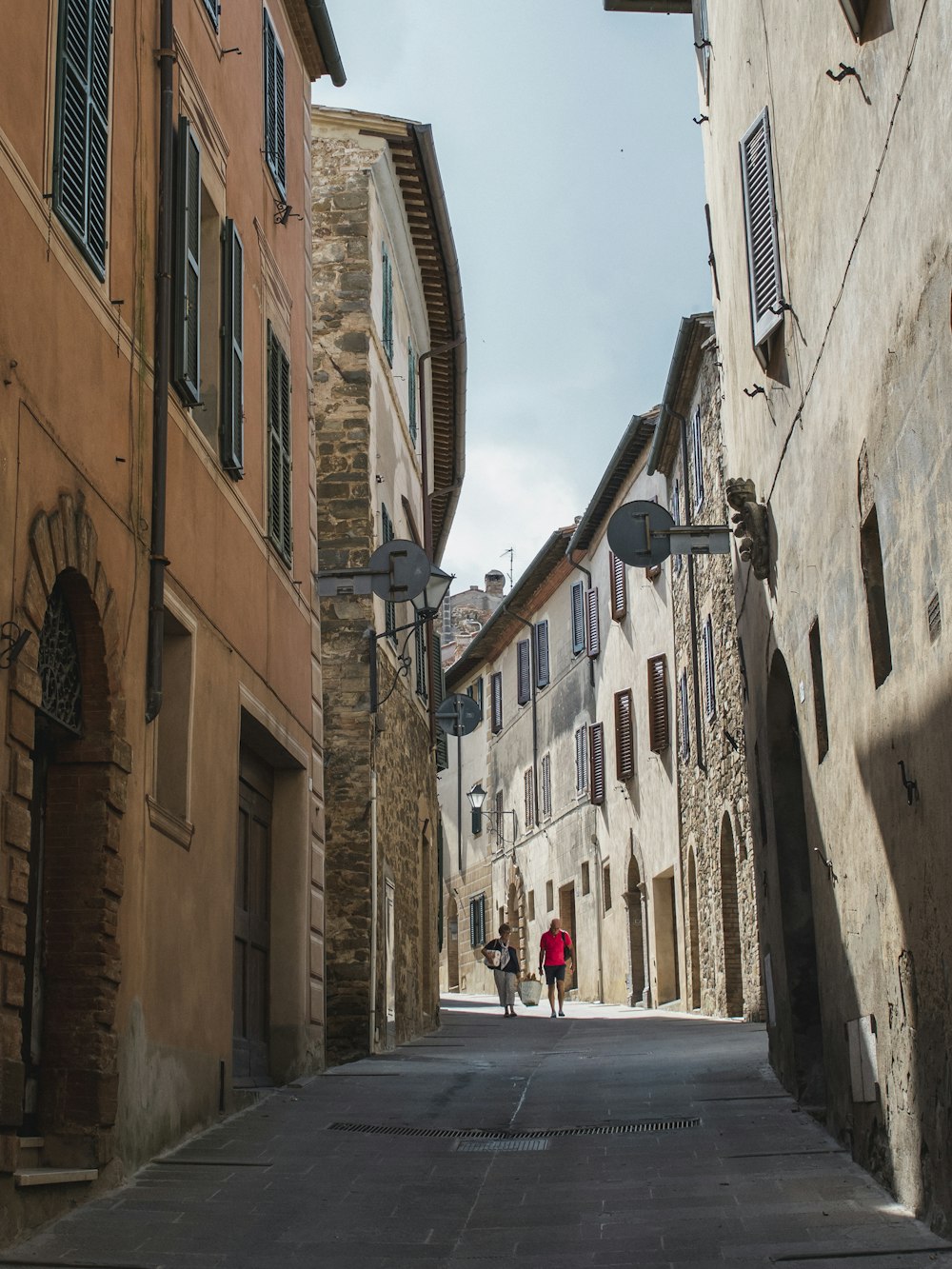 man walking behind building