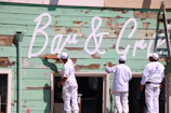 Close-up of painters carefully applying a fresh coat on a home's exterior siding.