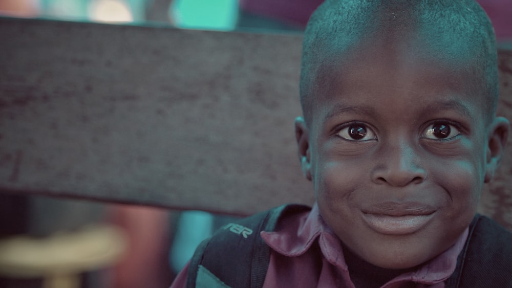 smiling boy sits on brown chair