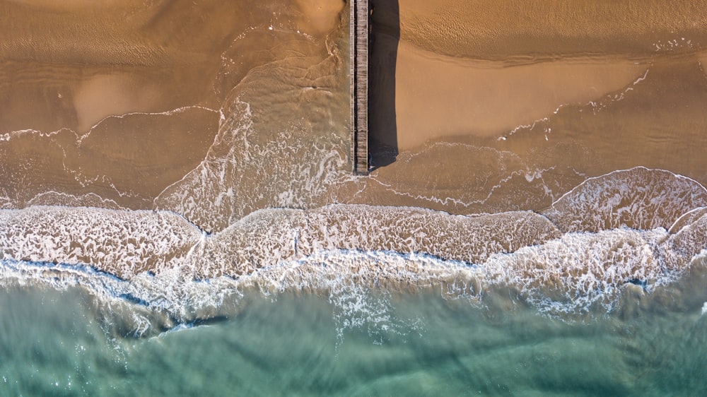 Fotografía aérea de un muelle de madera marrón junto al mar