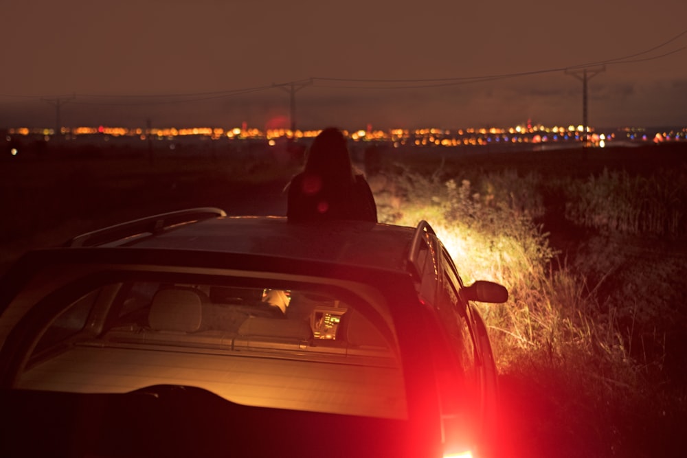 woman sitting in front of car