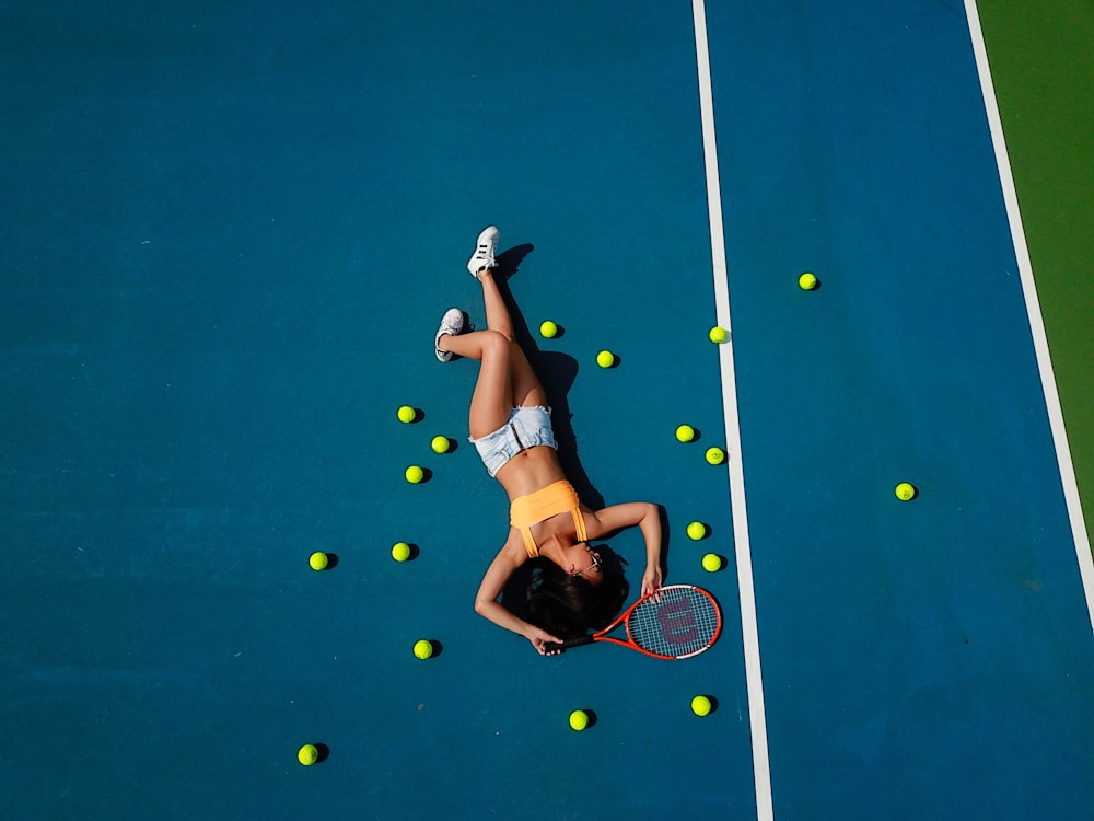woman in yellow crop top laying down on hard court