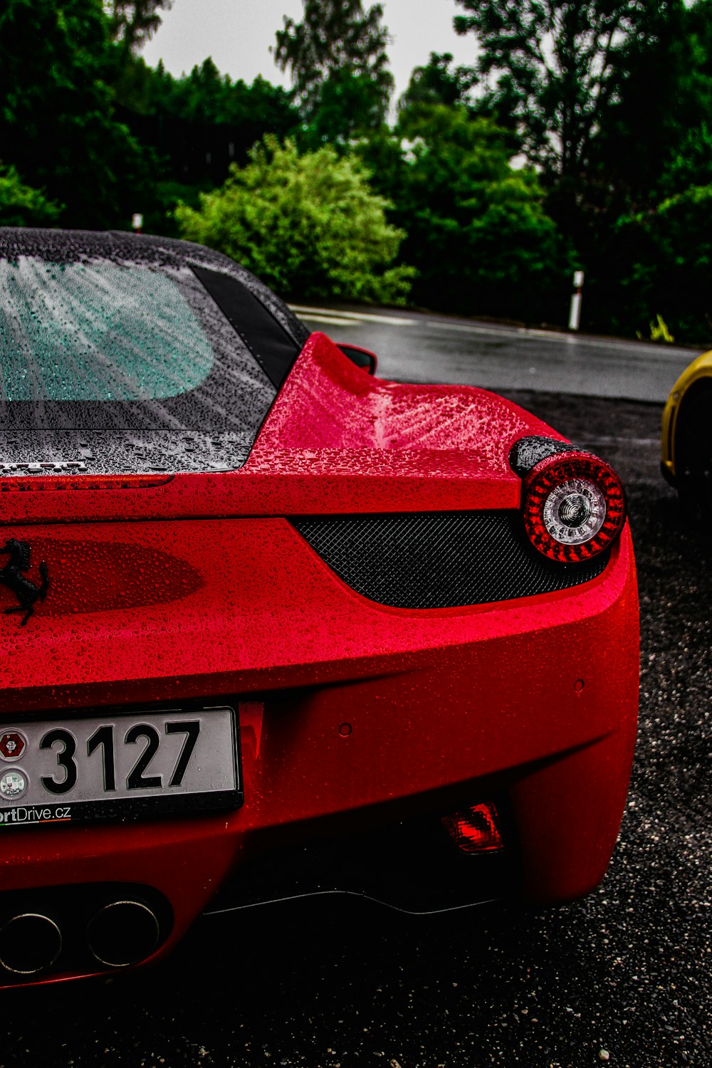 Ferrari rojo cerca de una carretera asfaltada durante el día