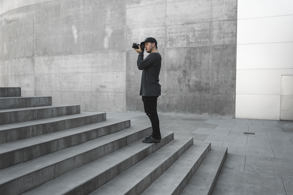 man taking picture of gray stairs