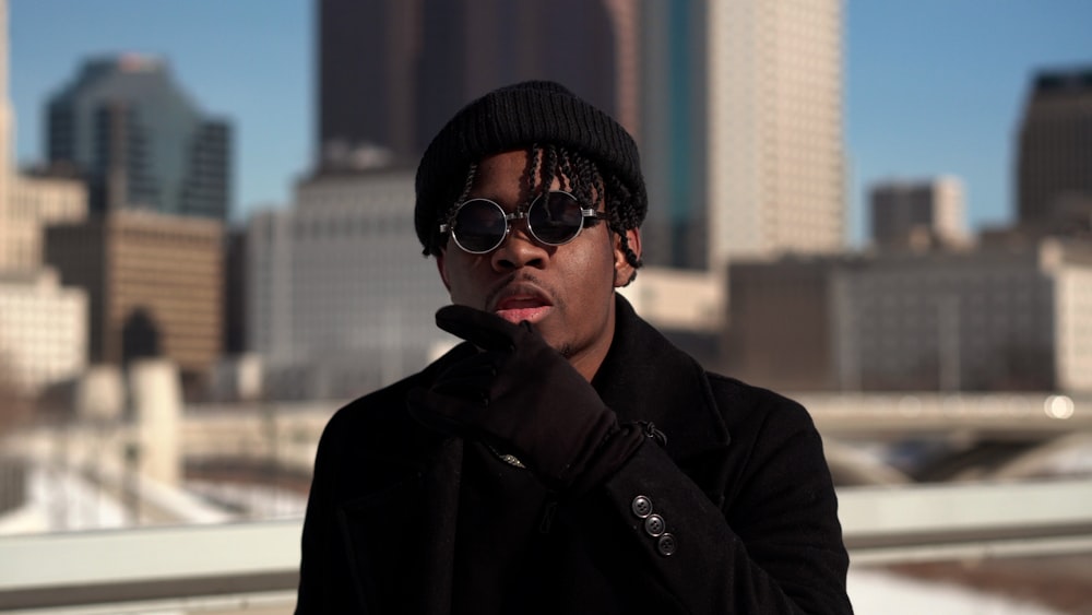 selective focus photography of man wearing black knit and sunglasses