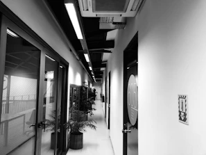 A row of smart doors with illuminated access panels in an office hallway