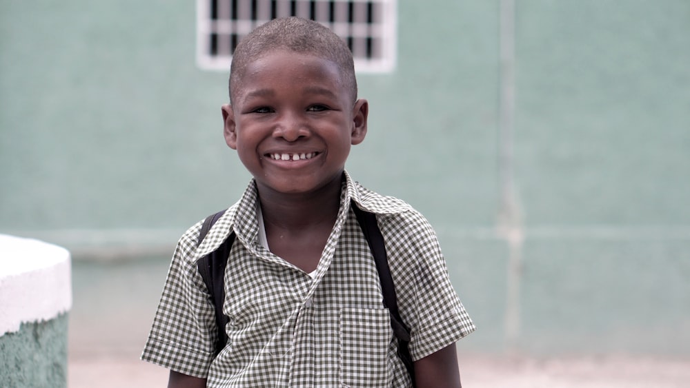 boy smiling carrying backpack