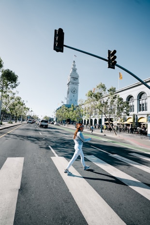 Model crossing a bustling crosswalk in Lumina Apparel’s latest athleisure line, embodying movement and energy.