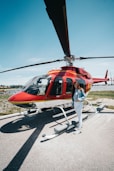 smiling woman standing near red helicopter