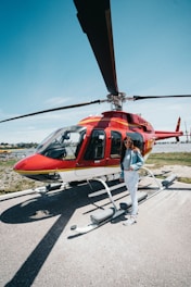 Elevé Group smiling woman standing near red helicopter