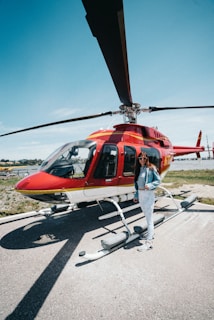 Elevé Group smiling woman standing near red helicopter