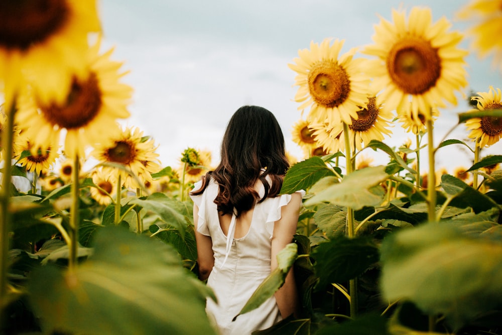 Frau umgeben von gelben Sonnenblumen