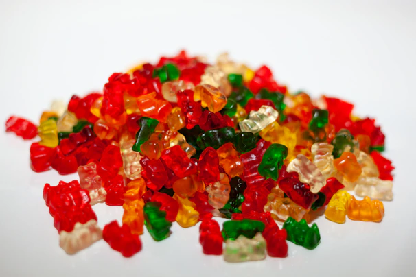 Close-up of vibrant red and green gummy bears piled in a bowl.
