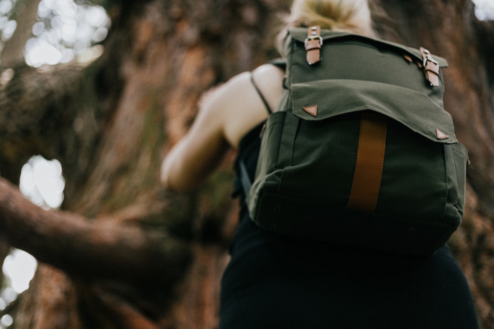 a woman with a bagpack hiking in nature.