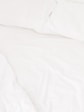 a close up of a bed with white sheets and pillows