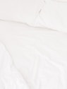 a close up of a bed with white sheets and pillows
