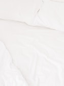 A neatly arranged bed with white sheets and pillows, conveying a sense of cleanliness and order. The fabric appears soft and inviting, suggesting comfort and relaxation.