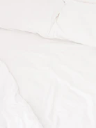 Smooth, crisp sheets in soft pastel colors spread across a bed