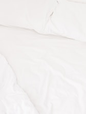 Comfortable bed with crisp white linens and soft pillows.