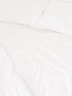 a close up of a bed with white sheets and pillows