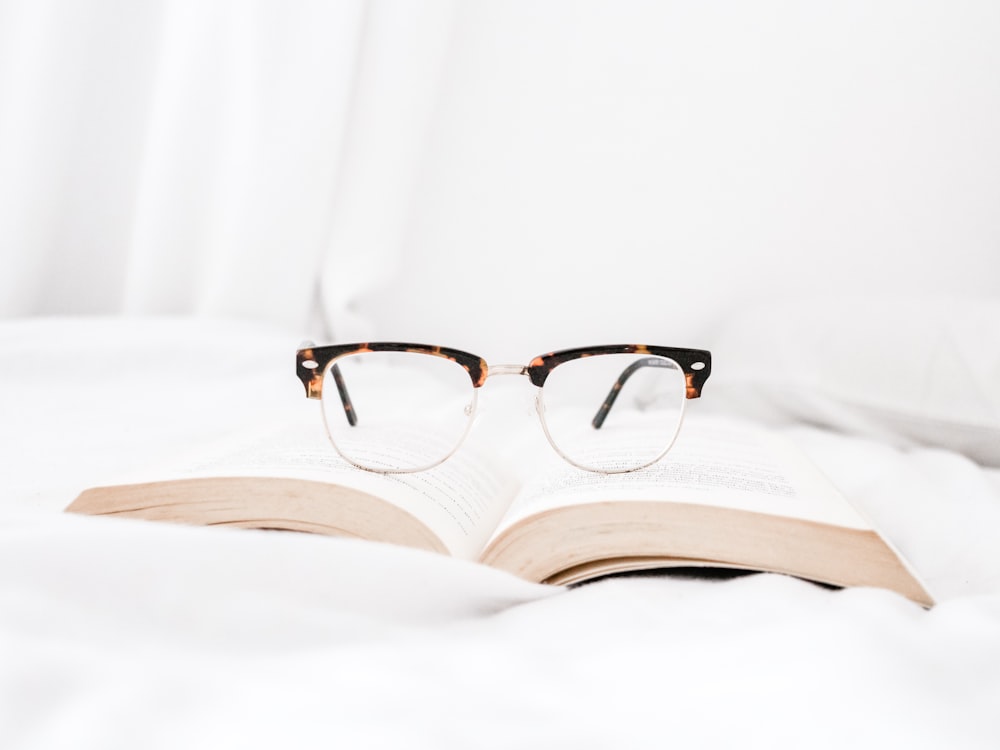 eyeglasses with tortoiseshell cat frames on book