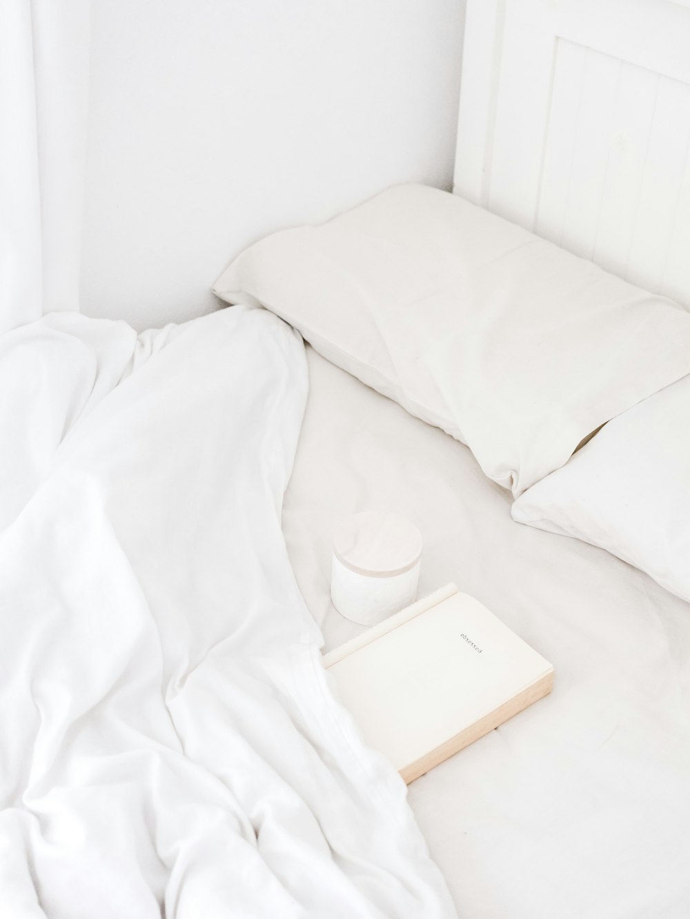 침대에 놓인 흰색 휴대용 스피커