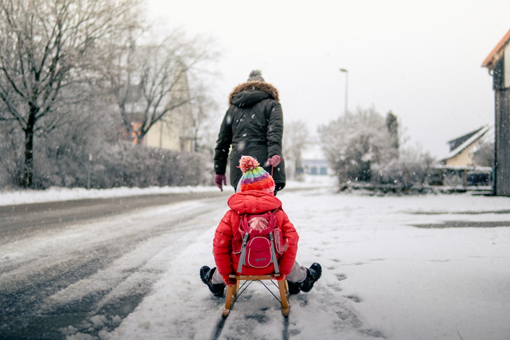 person pulling cart with boy