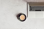 An open laptop with educational crypto materials and a coffee cup beside it.