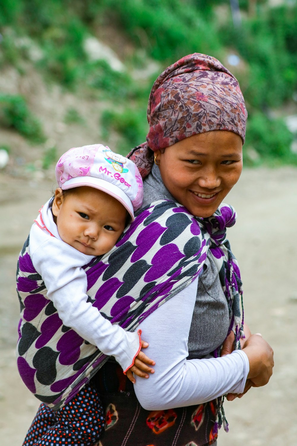 smiling woman carrying child on back