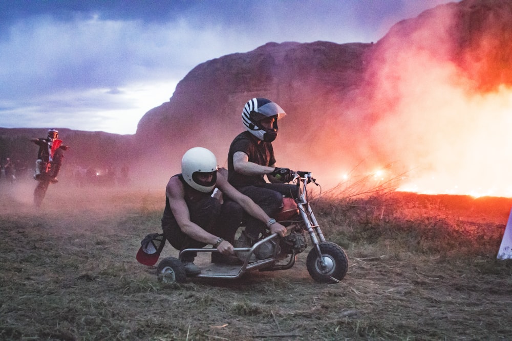 two men riding motorcycle with cart